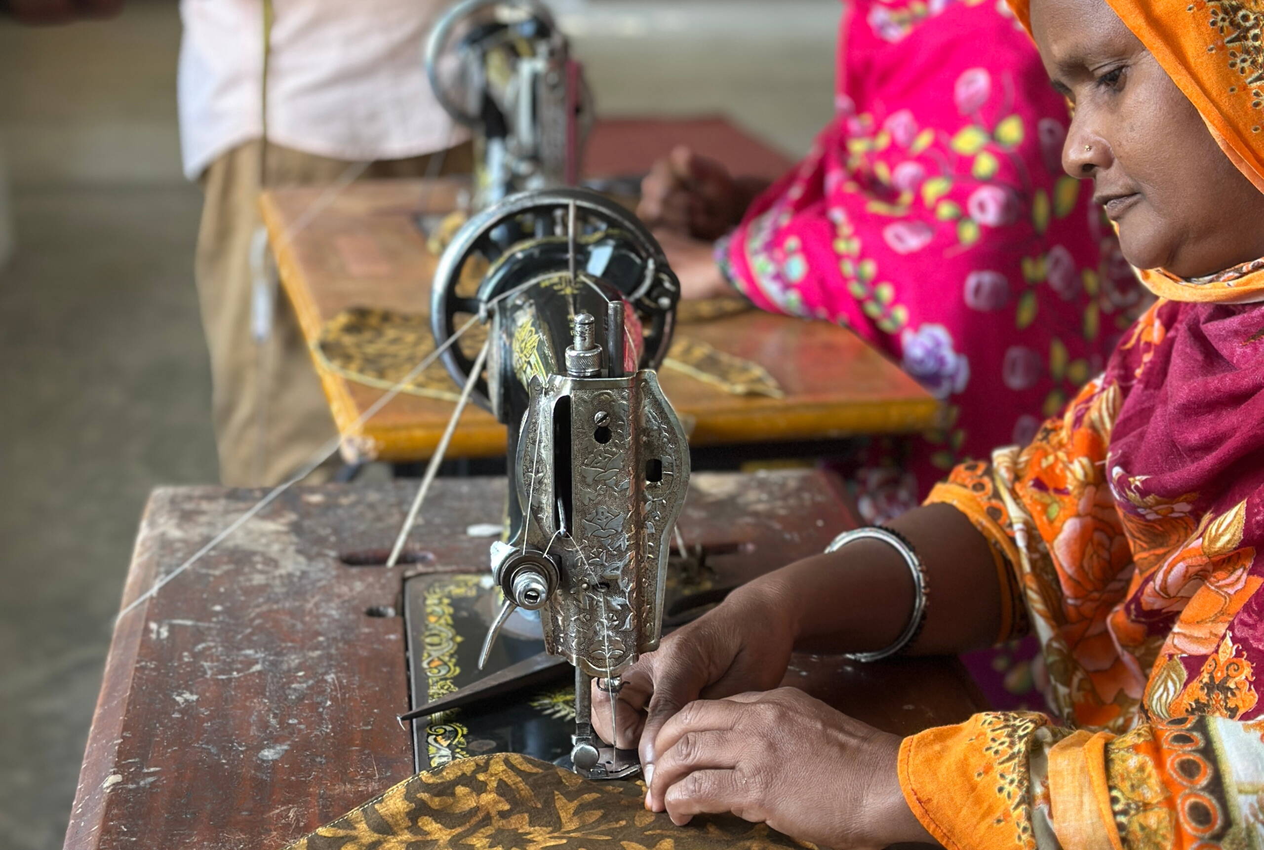 Sanwara Eine Frau näht ein farbiges Lätzli.