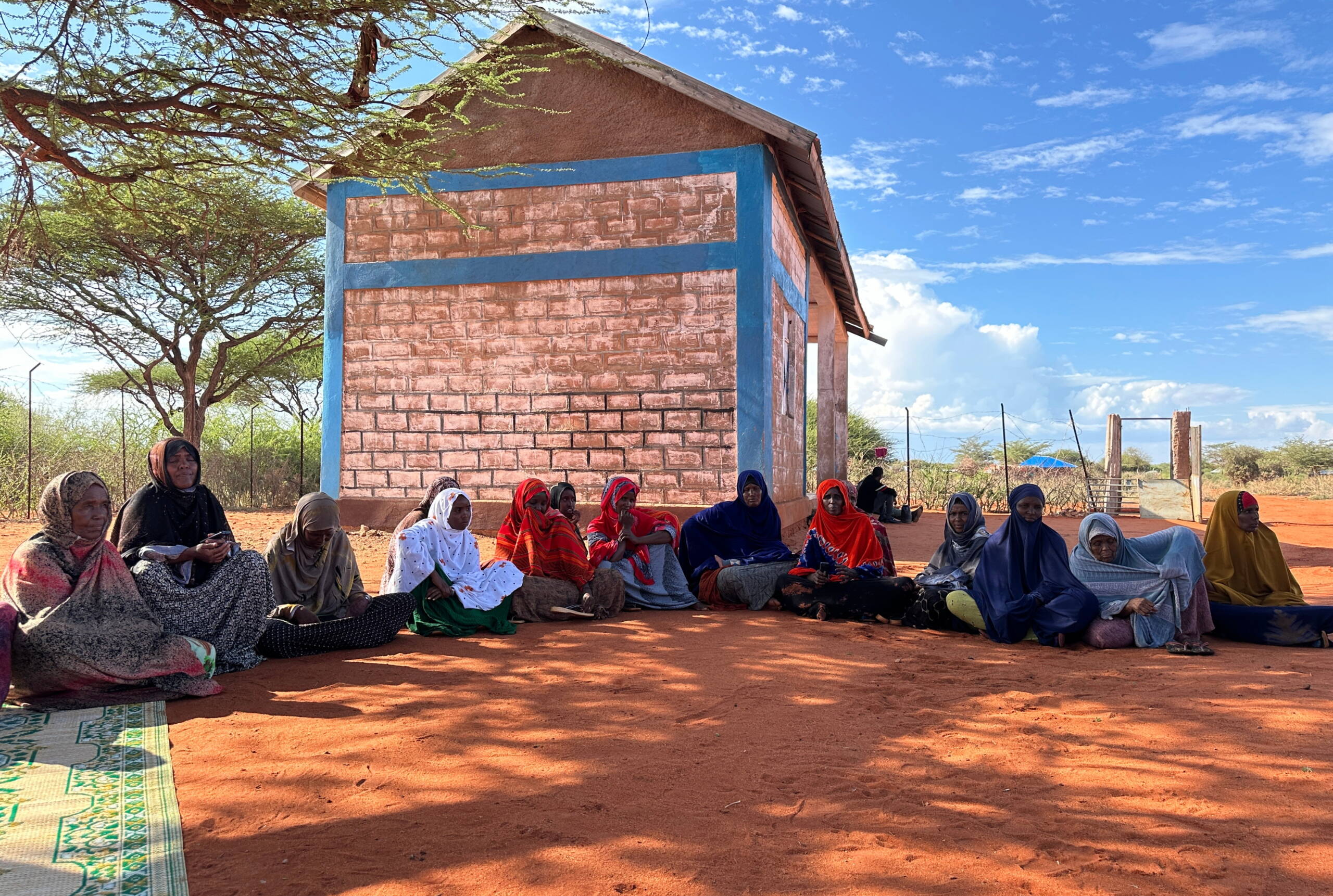 Frauen sitzen am Boden und diskutieren.