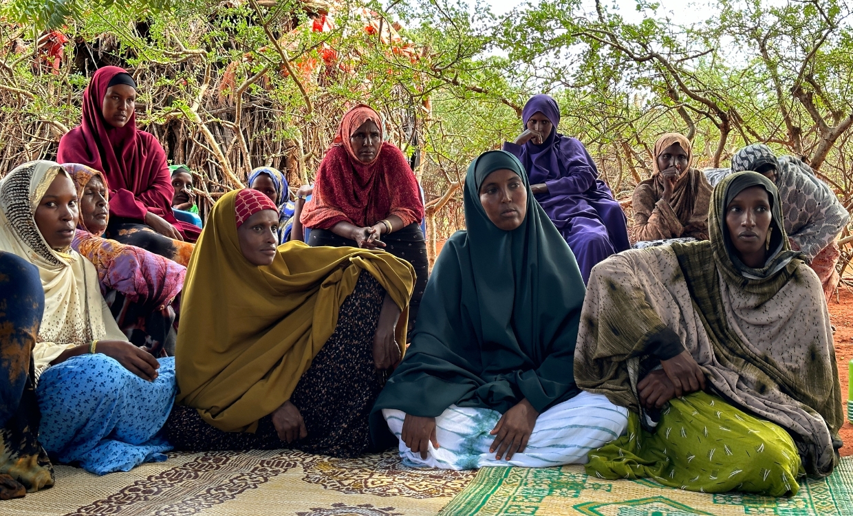 Engagement gegen weibliche Genitalbeschneidung Frauen sitzen am Boden und hören zu.
