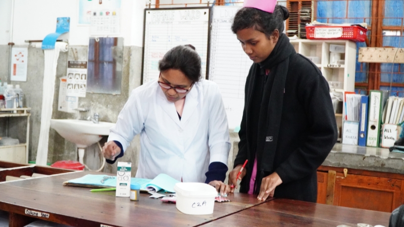 LAMB Eine Hebammenstudentin und eine Ärztin beugen sich über ein Medikament.