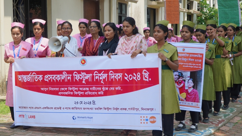 Frauen laufen in einer Reihe und halten ein Transparent hoch.