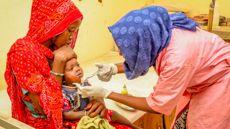 Nothilfe für Frauen und Kinder aus dem Sudan Eine Hebamme behandelt eine Wunde im Gesicht eines kleinen Mädchens.