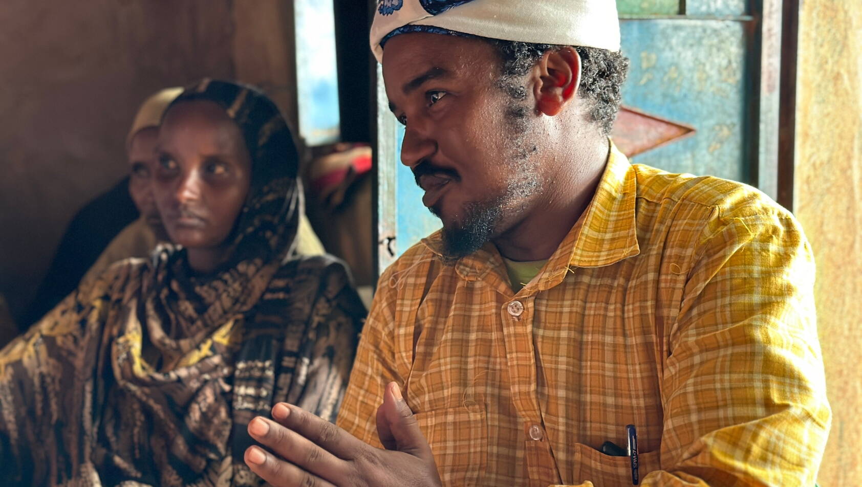 Ein Mann mit Turban spricht zu einer Gruppe.