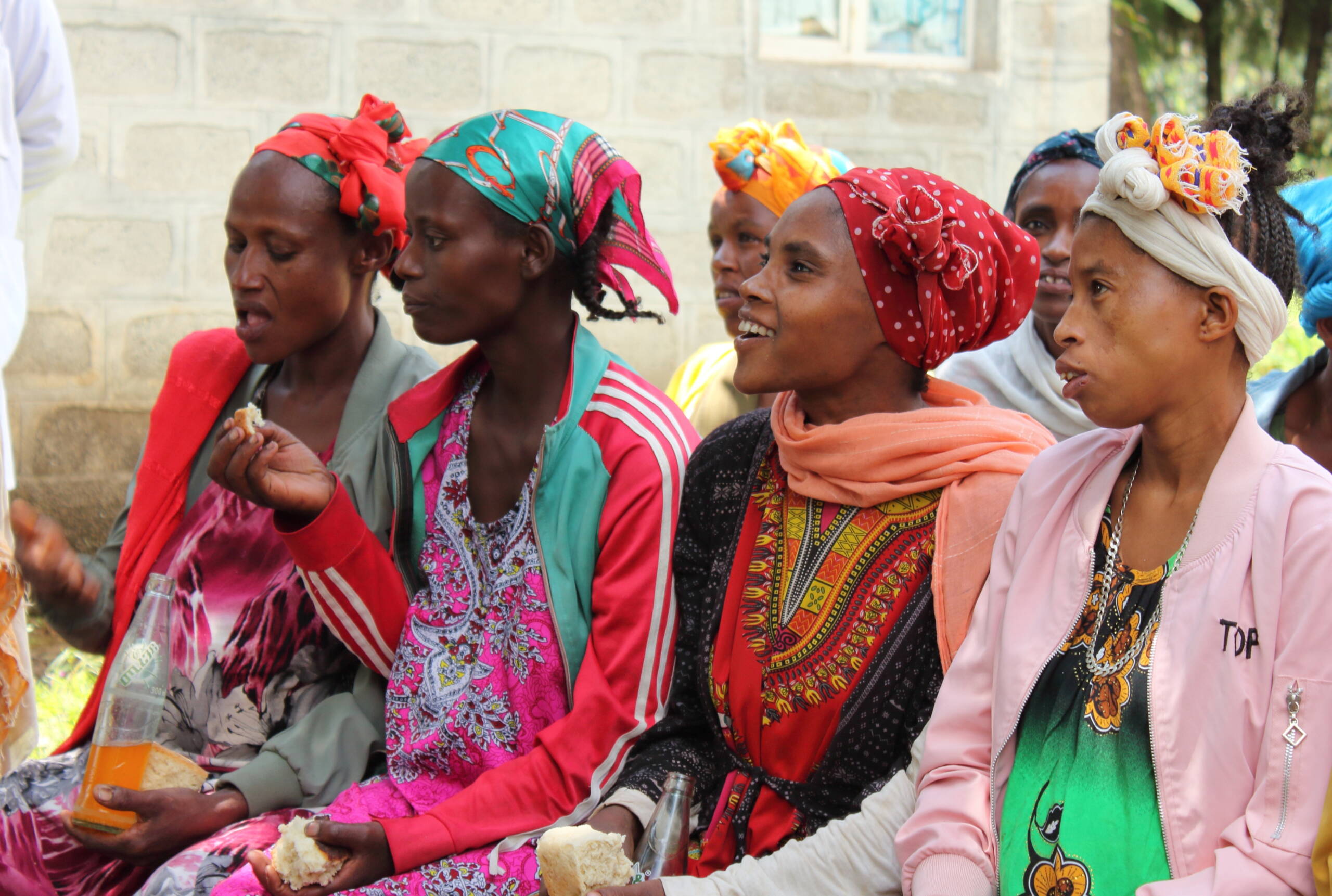 Frauen sitzen in einer Reihe und lauschen gespannt.