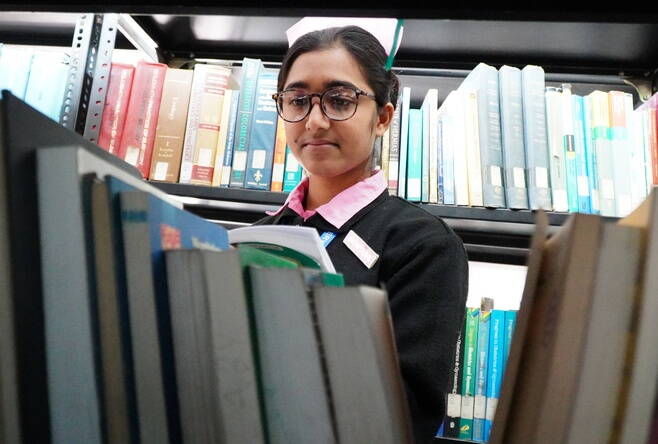 Eine junge Frau blättert in einem Buch.