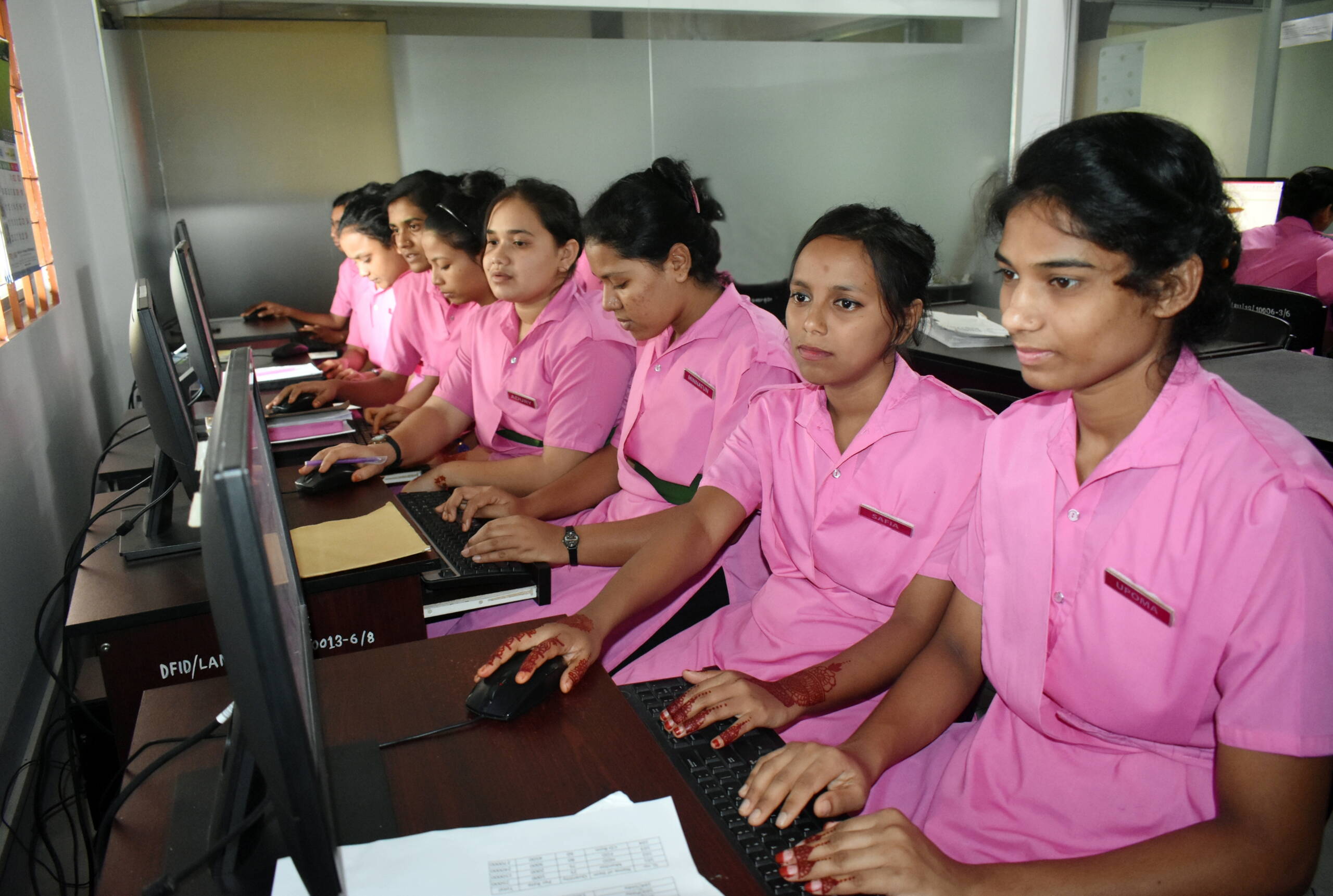 Hebammenstudentinnen sitzen vor Computer und lernen.
