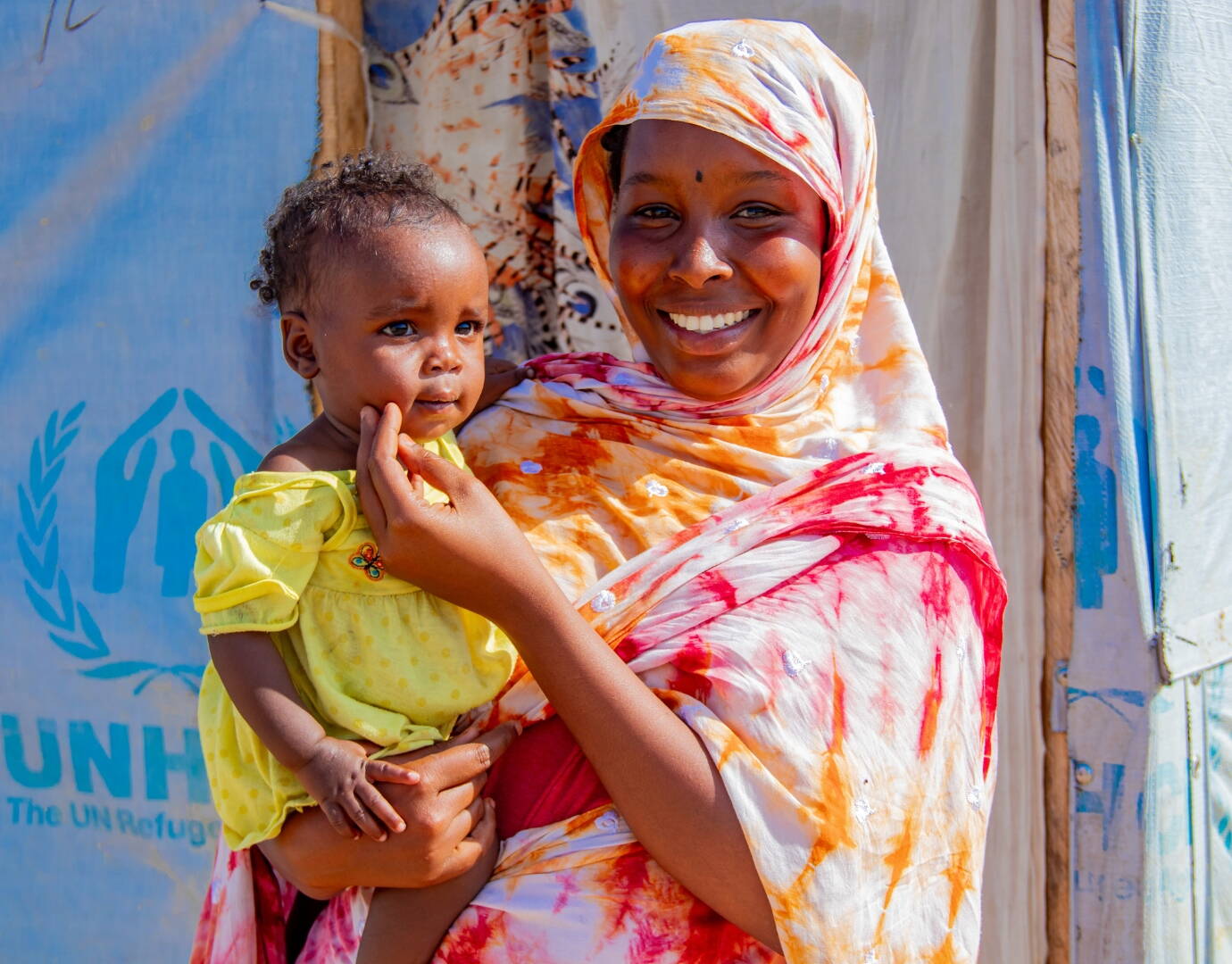 Mutter mit Kleinkind auf dem Arm.