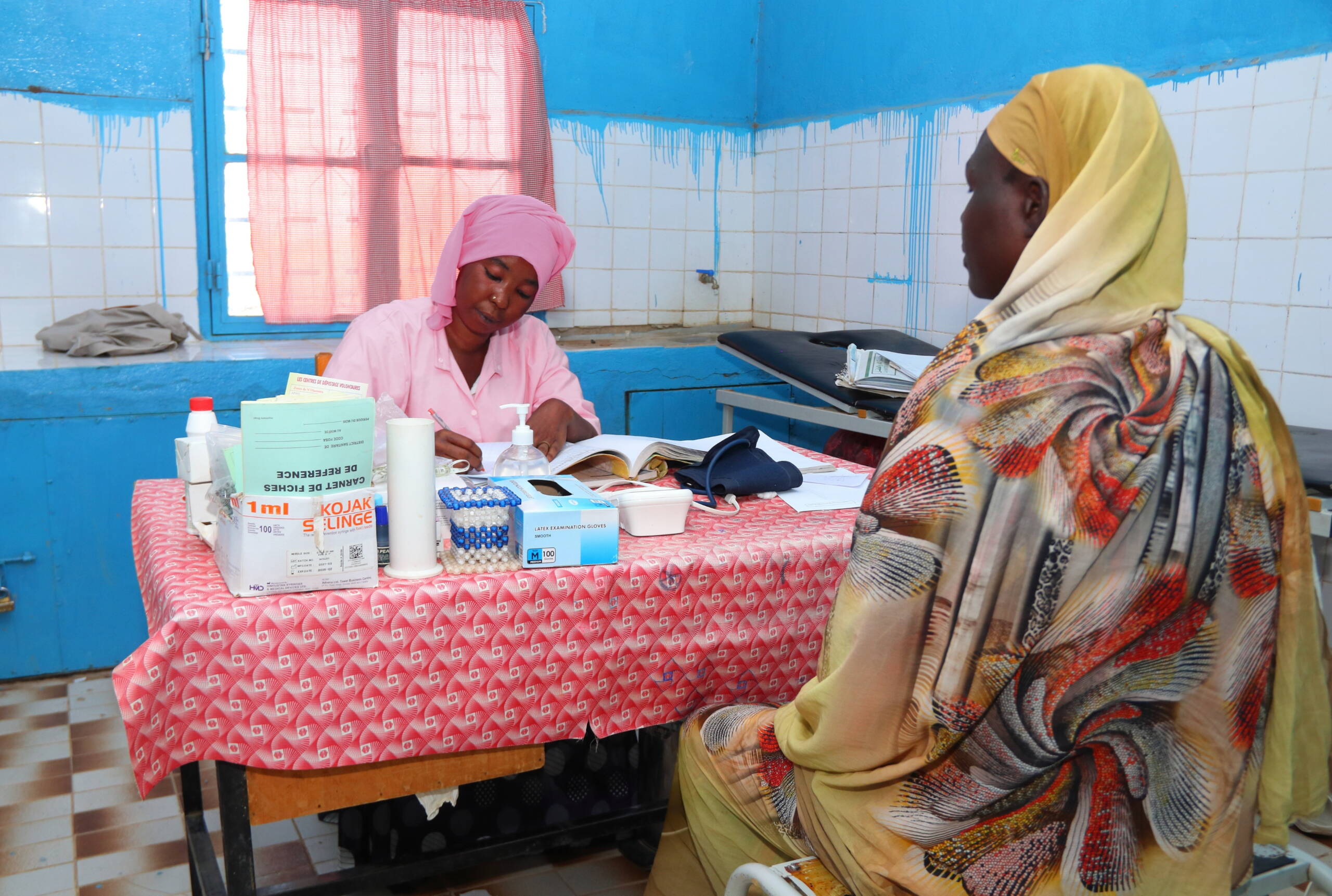 Eine Hebamme im Gespräch mit einer schwangeren Frau.