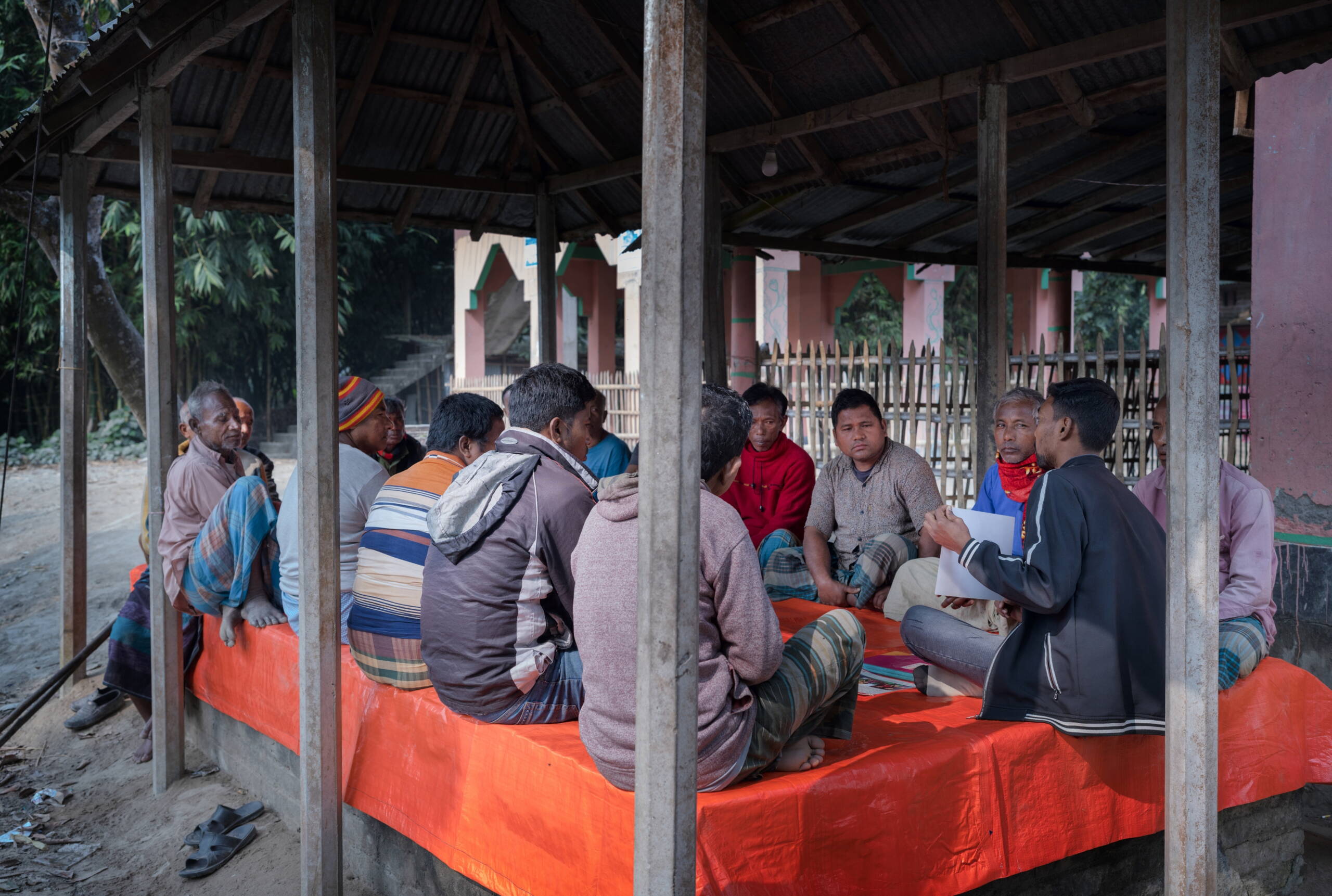Männer sitzen auf dem Boden und tauschen sich aus.