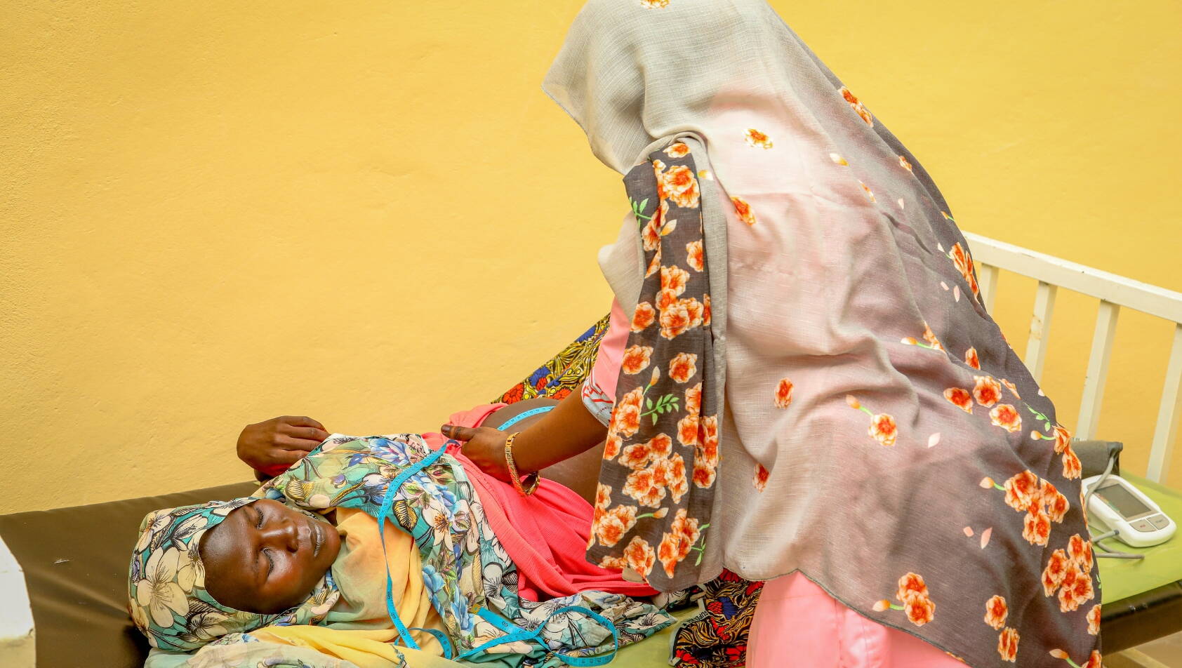 Eine Hebamme untersucht eine schwangere Frau.