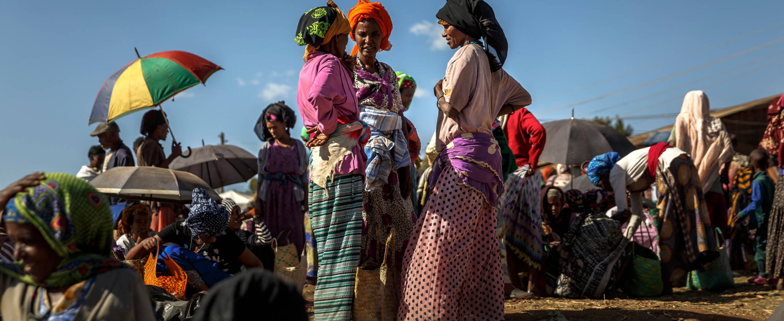 Frauen stehen auf einem Markt nahe beieinander und unterhalten sich.