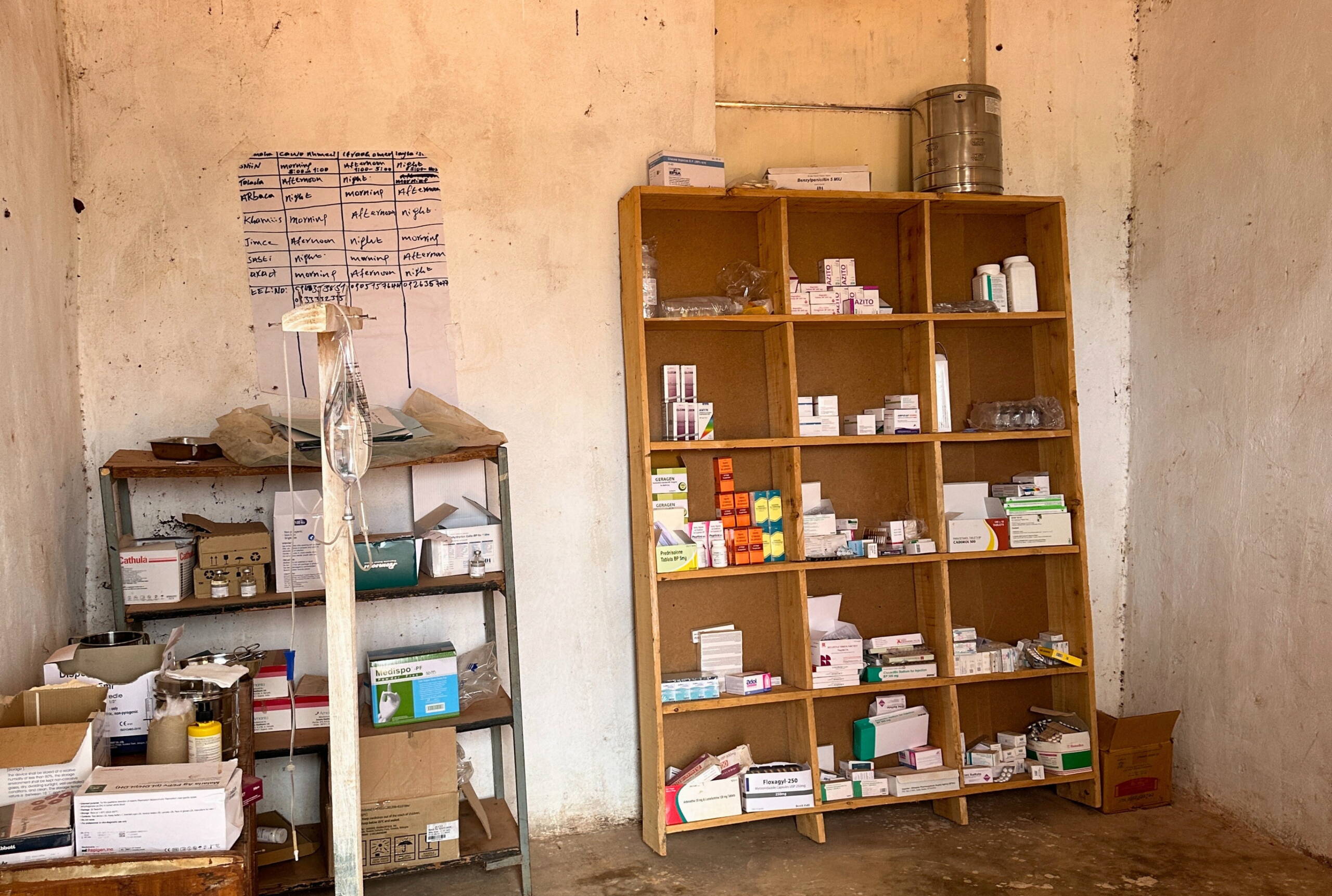 Blick in Behandlungsraum mit dreckigen Wänden, davor zwei Gestelle mit etwas Medikamenten drauf.