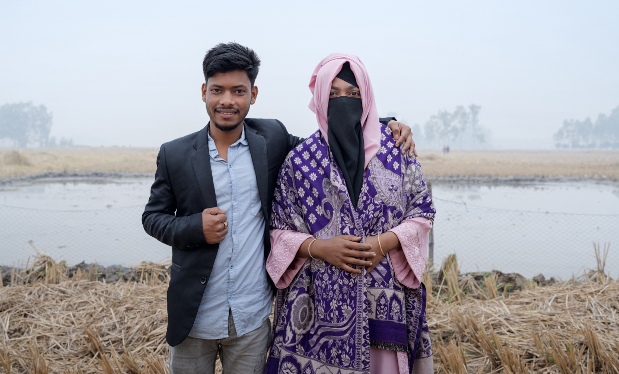 Ein junges Paar steht nebeneinander, sie ist vollverschleiert.