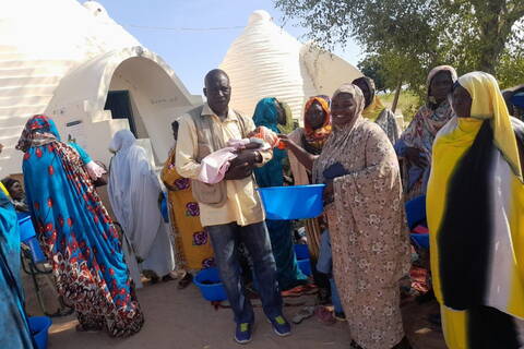 Newborn child in front of Maternité, Chad