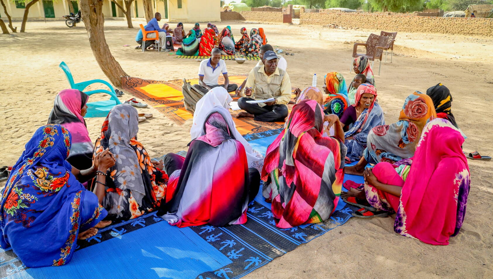Befragung Gemeinschaft Tschad Gespräch zwischen lokalem Projektmitarbeiter und Frauen im Osten des Tschads.