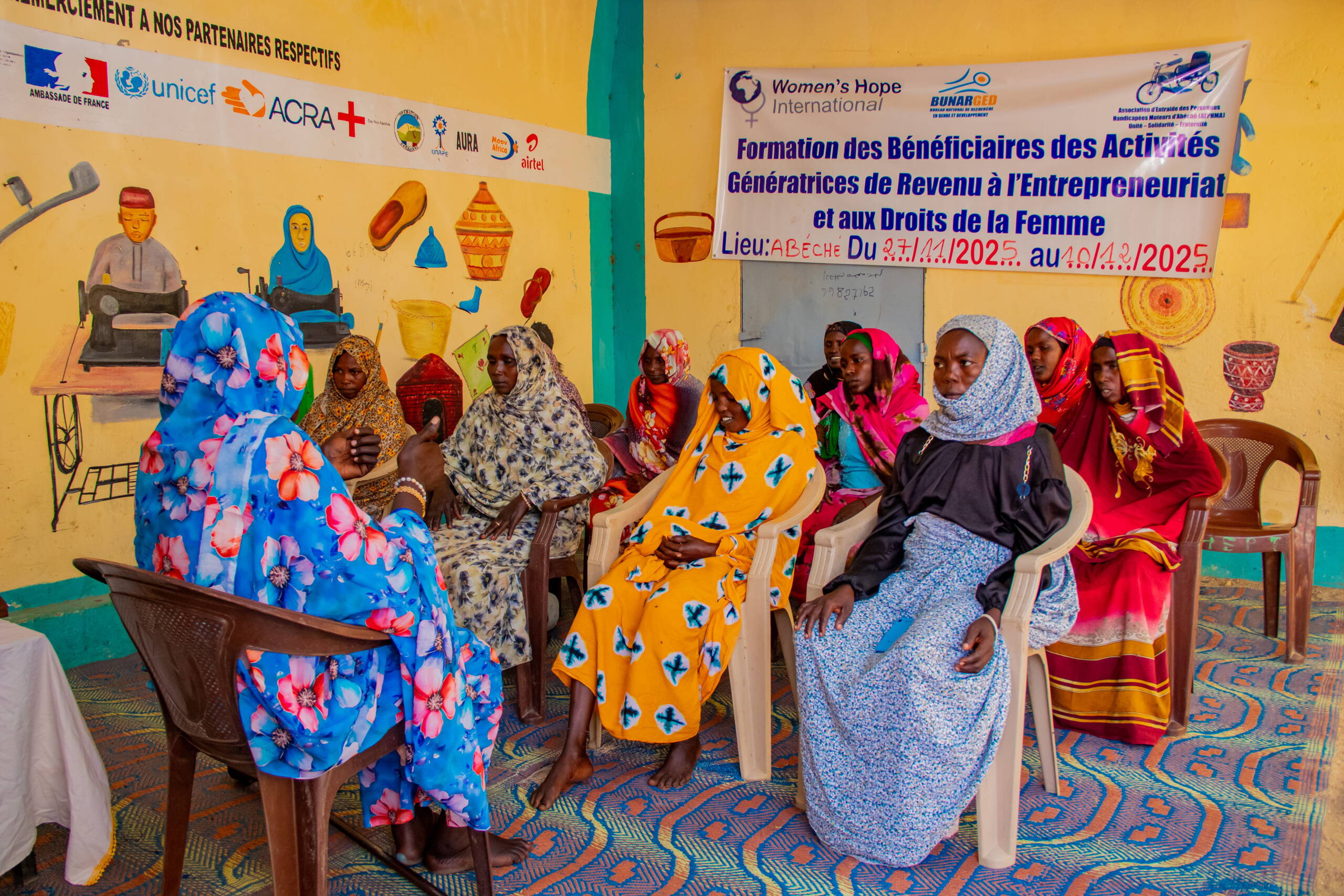 Eine Frau sitzt vor einer Gruppe Frauen, die zuhören.