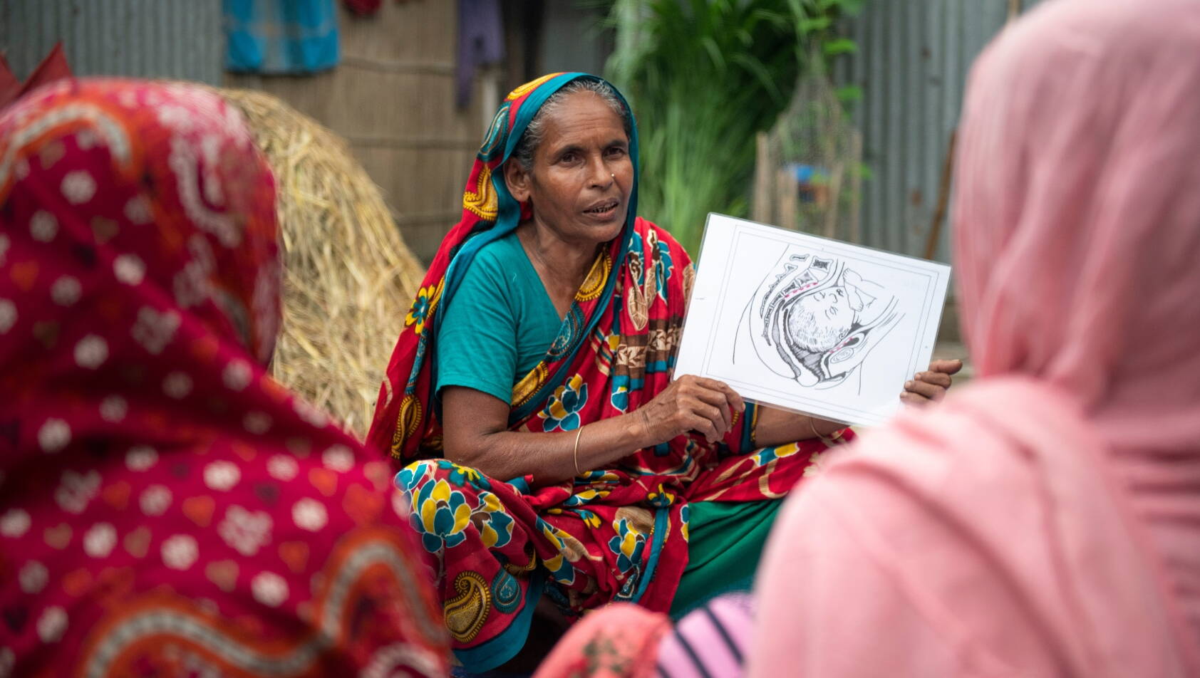 Fisteladvokatin bei Sensibilisierung hält Schulungsmaterial in die Kamera