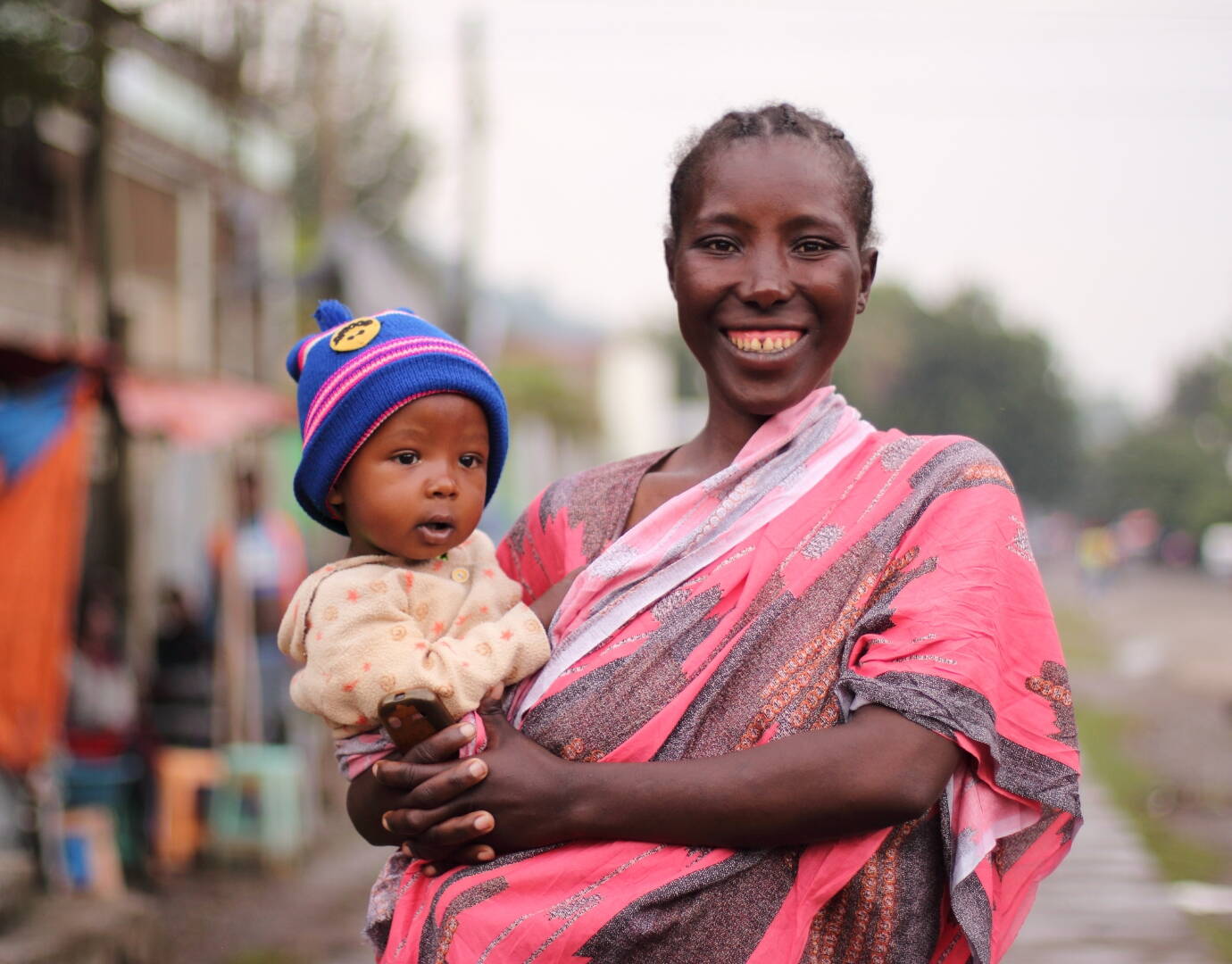 Junge Frau mit Kleinkind auf dem Arm.