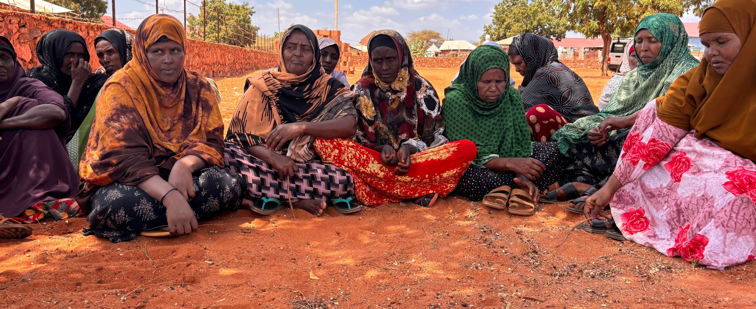 Frauen sitzen am Boden und diskutieren.