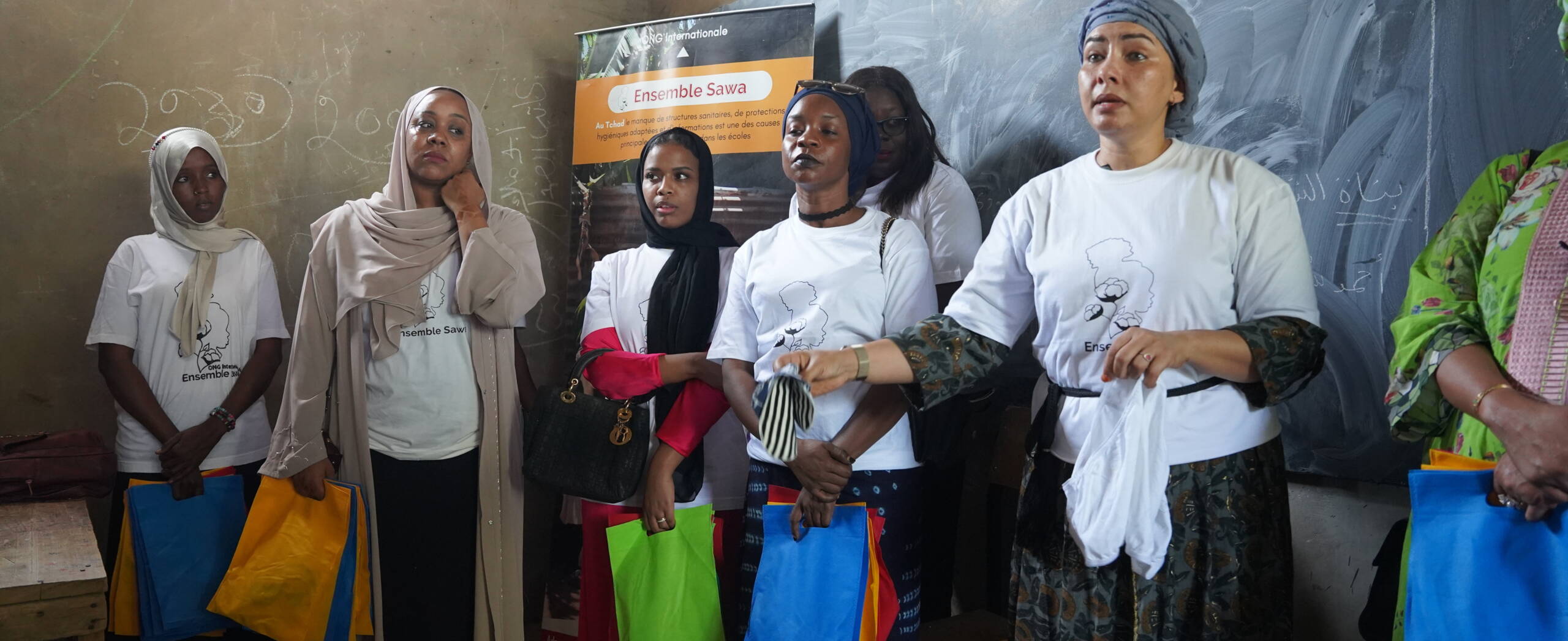 Verteilung von Binden in Schulen, Tschad Frauen der Partnerorganisation Ensemble Sawa verteilen Binden in einer Schule im Tschad