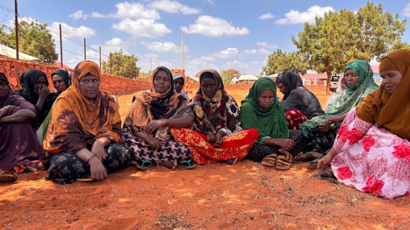 Frauen sitzen am Boden und diskutieren.