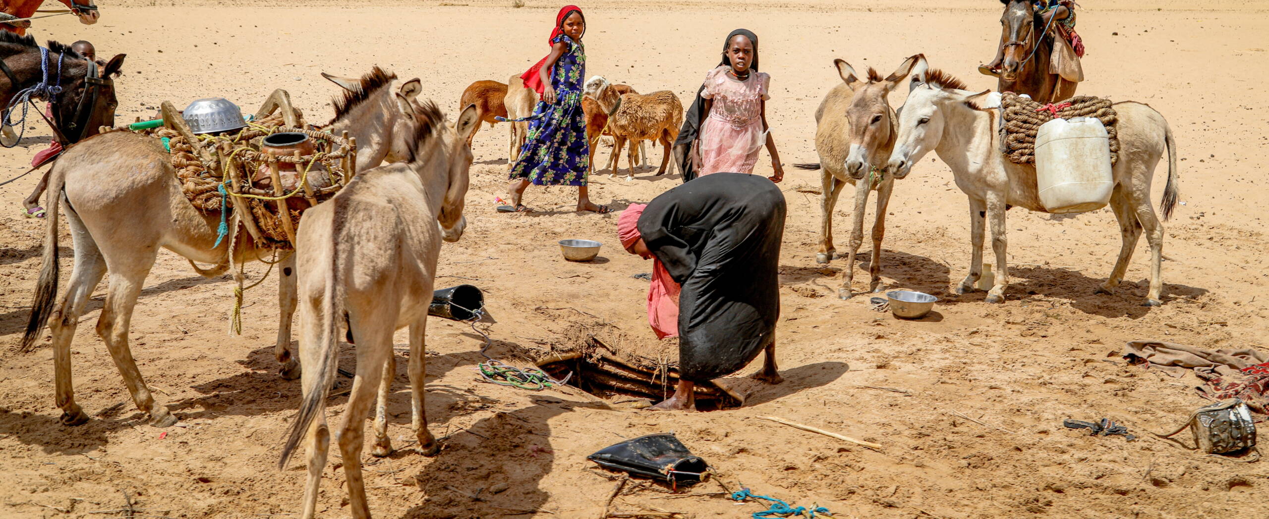 Mädchen stehen um eine Wasserstelle im Tschad