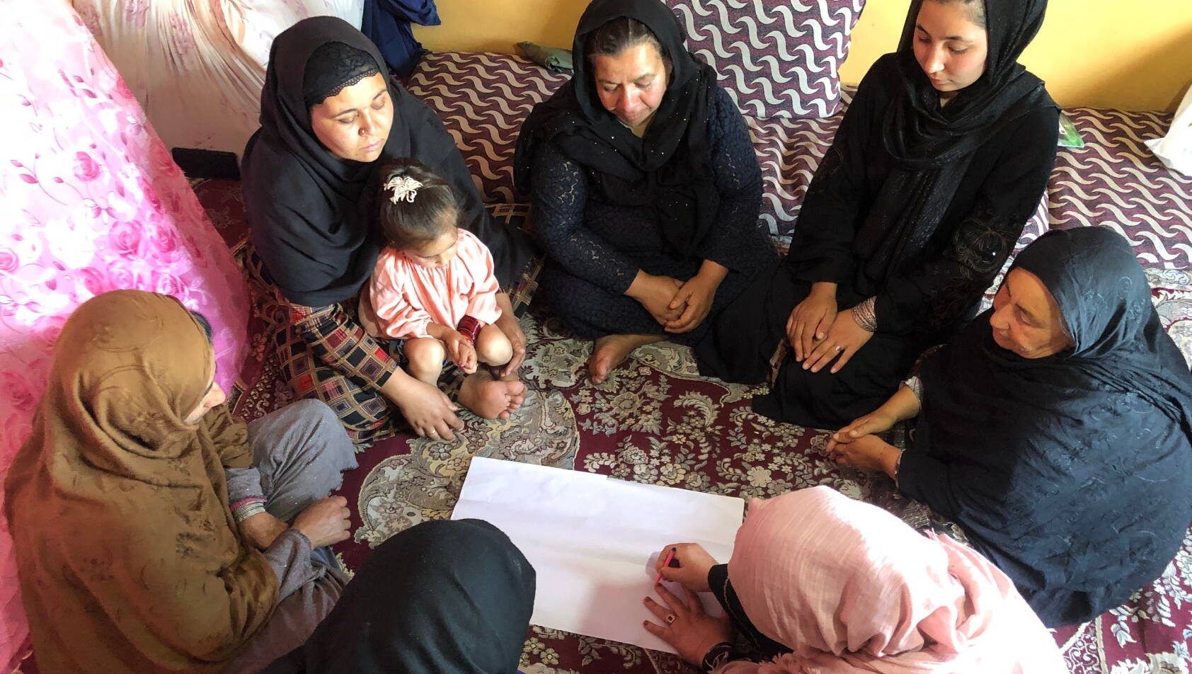 Frauen sitzen im Kreis bei einer Gruppenarbeit in der Selbsthilfegruppe in Afghanistan.
