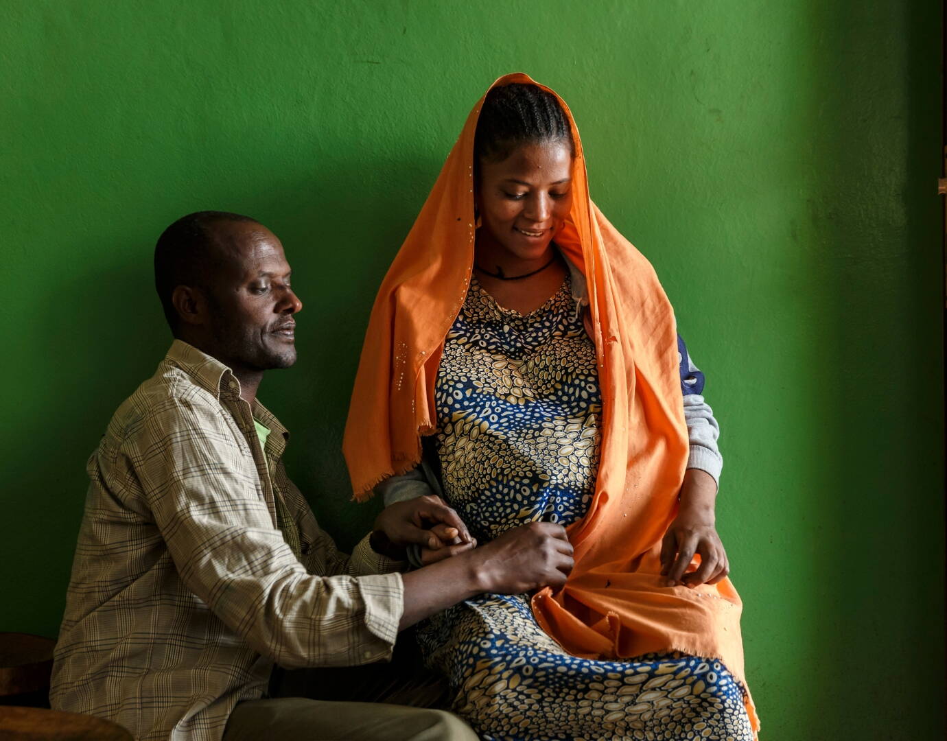 Ein Mann befühlt den schwangeren Bauch seiner Frau.