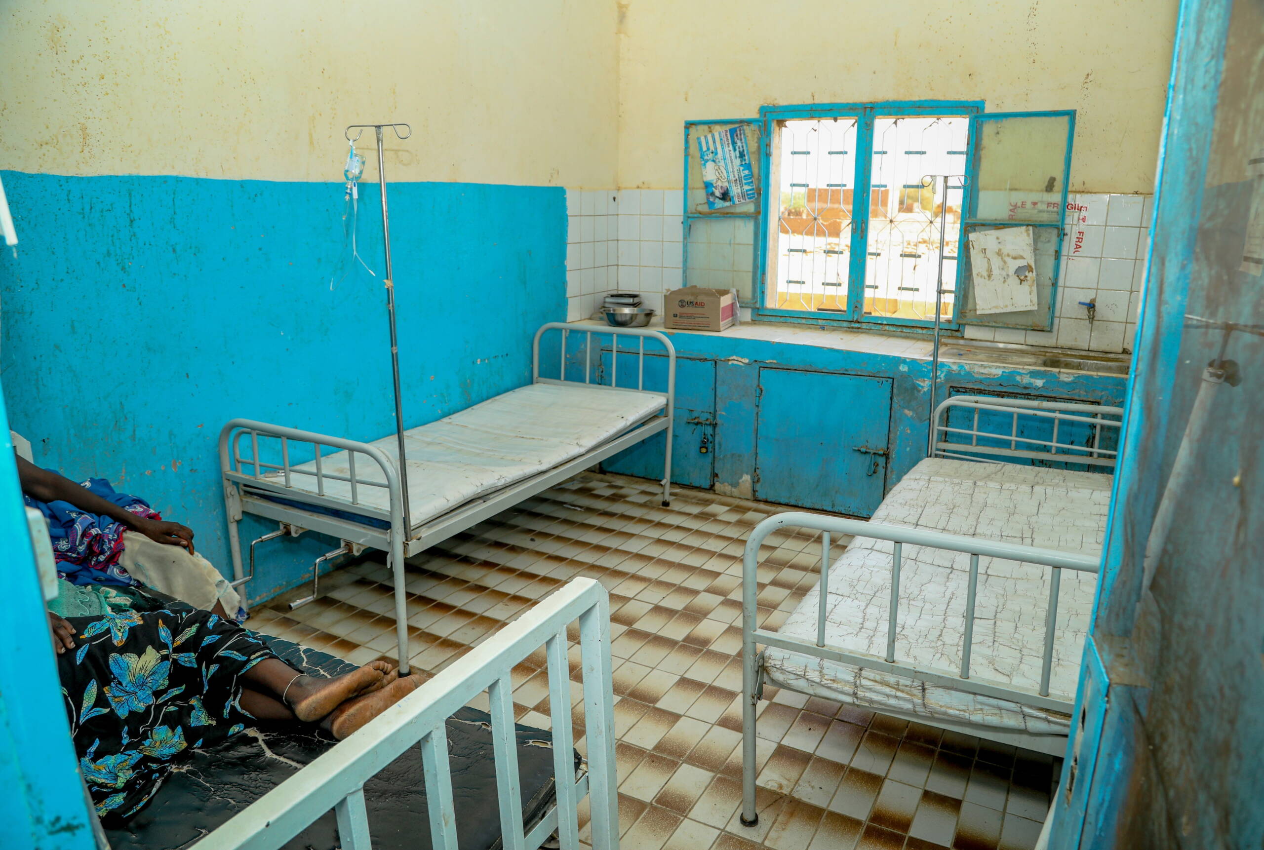 Gesundheitszentrum Drei Betten in einem spärlich eingerichteten Raum.