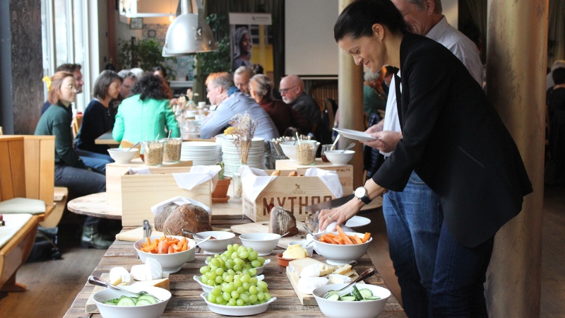 Anlasssspende Menschen an einem Brunch-Buffet.