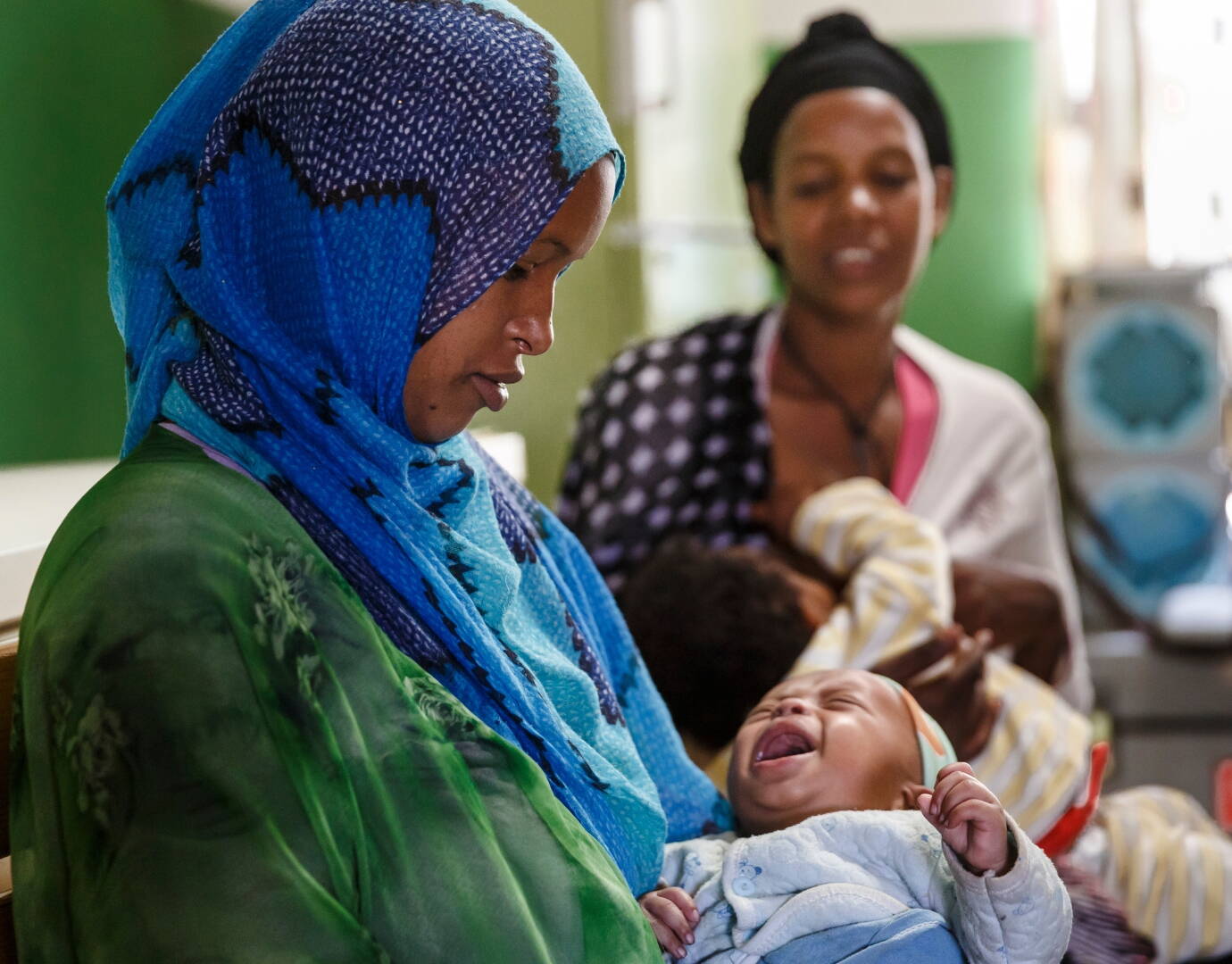 Jetzt spenden! Mädchen sitzen stolz hinter einem Laptop.