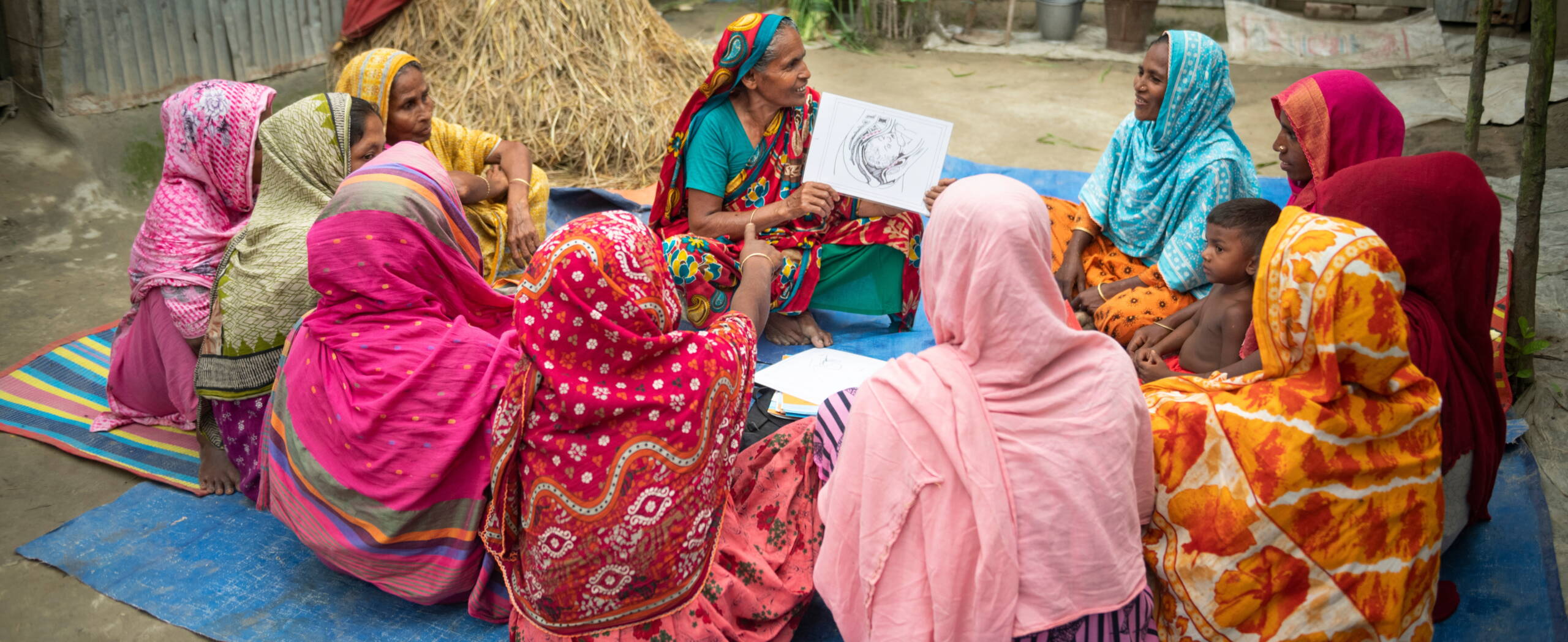 Frauen sitzen im Kreis, eine Frau spricht über Geburtsfisteln.