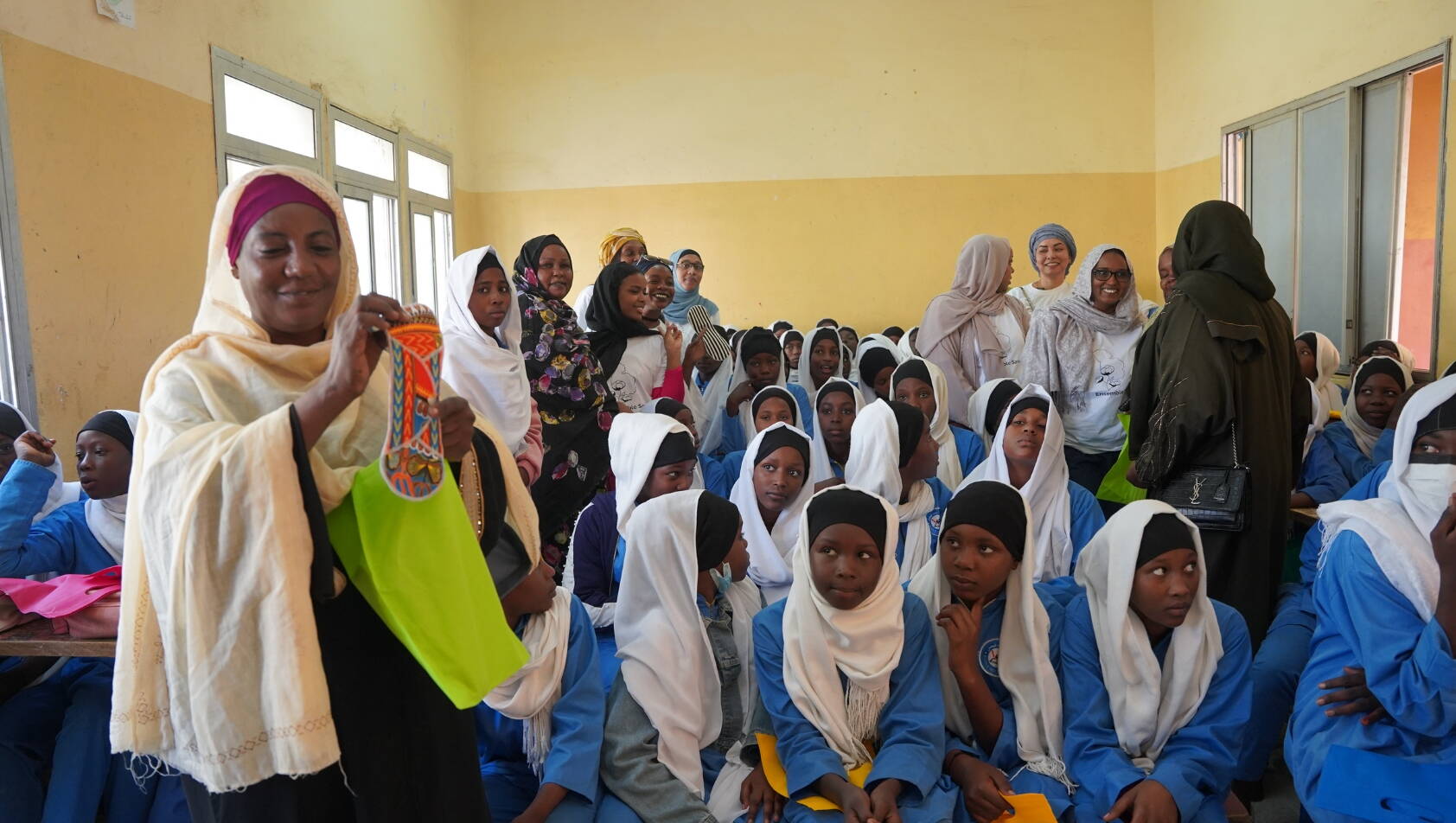 Verteilung von Binden in einer Schule, Tschad Frauen der Partnerorganisation Ensemble Sawa verteilen Binden in einer Mädcheklasse im Tschad