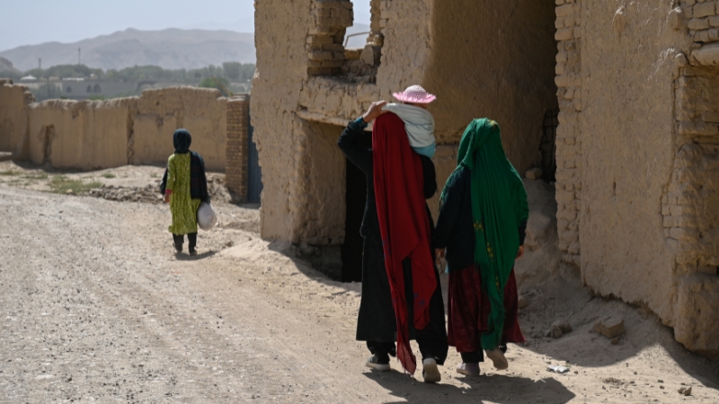Frauen laufen durch ein Dorf in Afghanistan.