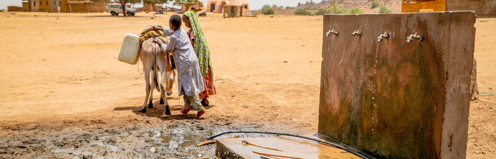 Kinder transportieren Wasser von einer Wasserstelle im Tschad