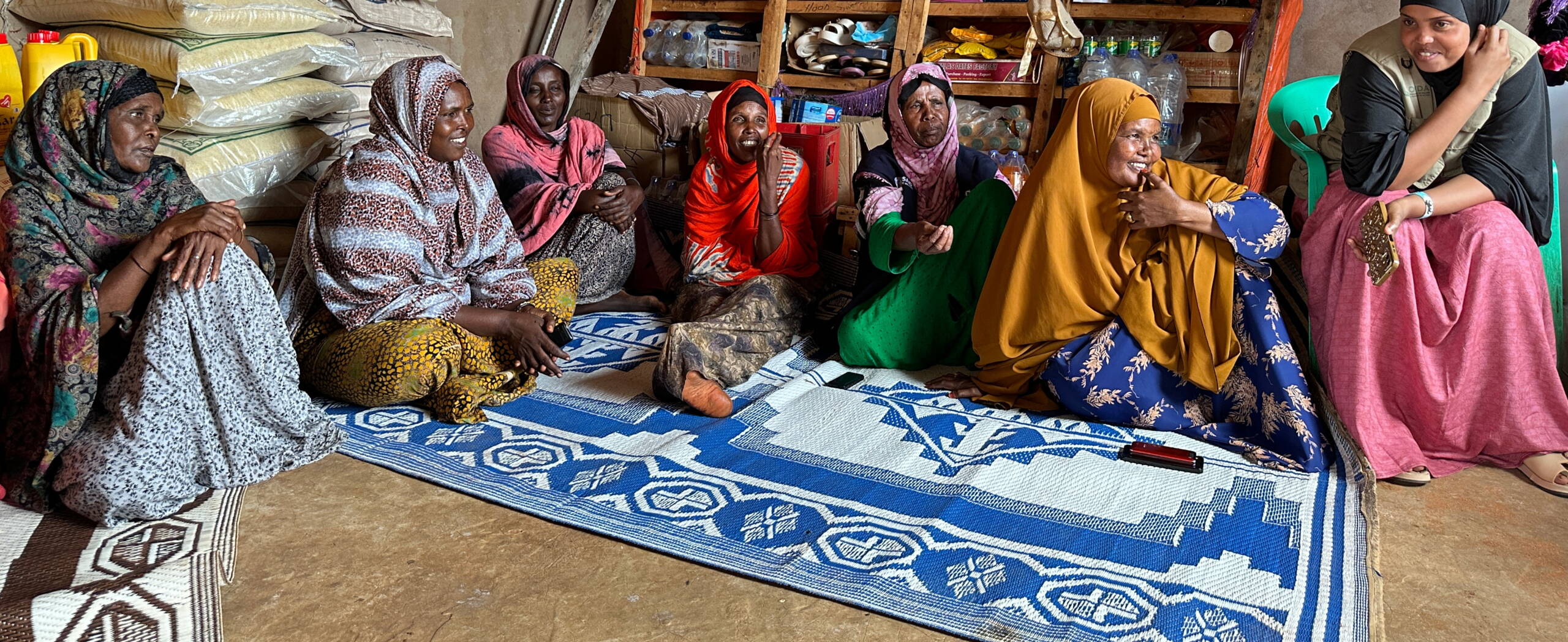 Frauen sitzen am Boden und diskutieren.