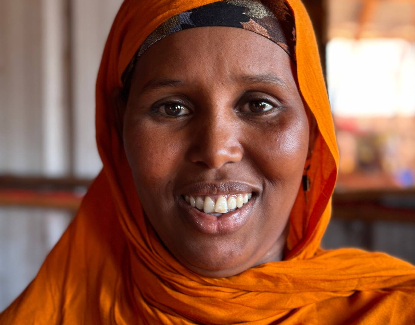 Jetzt spenden! Eine Frau lächelt gewinnend in die Kamera.