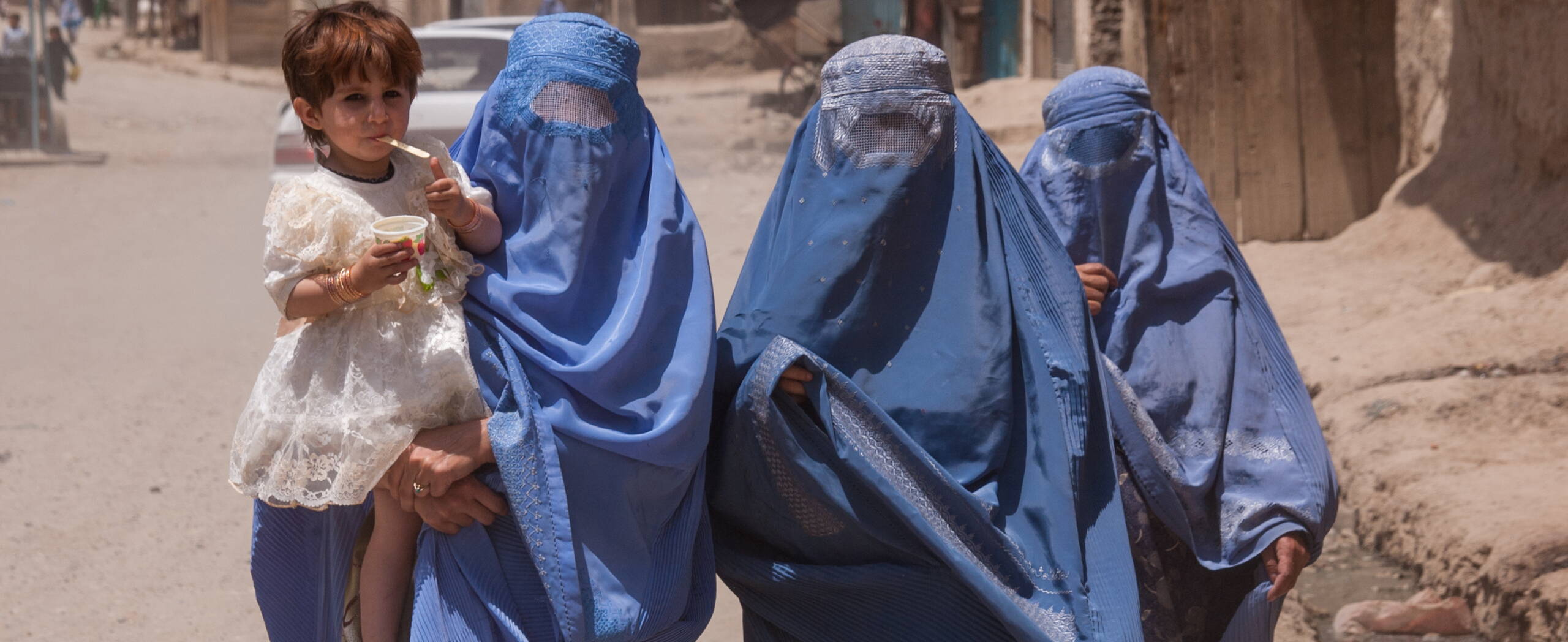 Zwei Frauen in Burqas mit Kindern in Afghanistan.