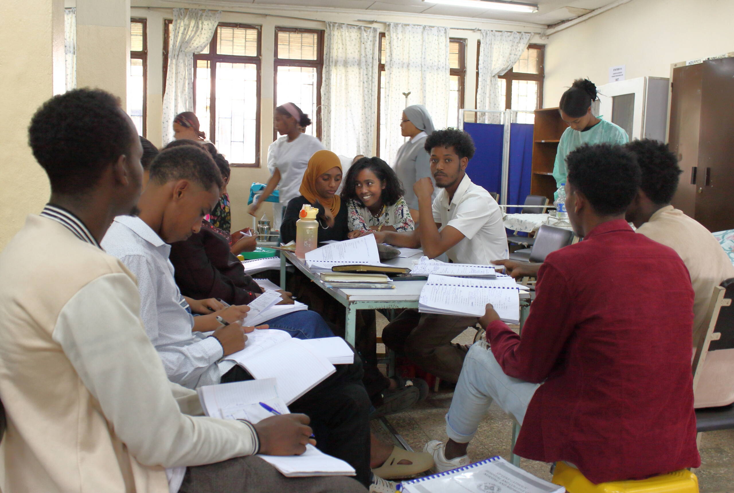 Studierende sitzen um einen Tisch und unterhalten sich.