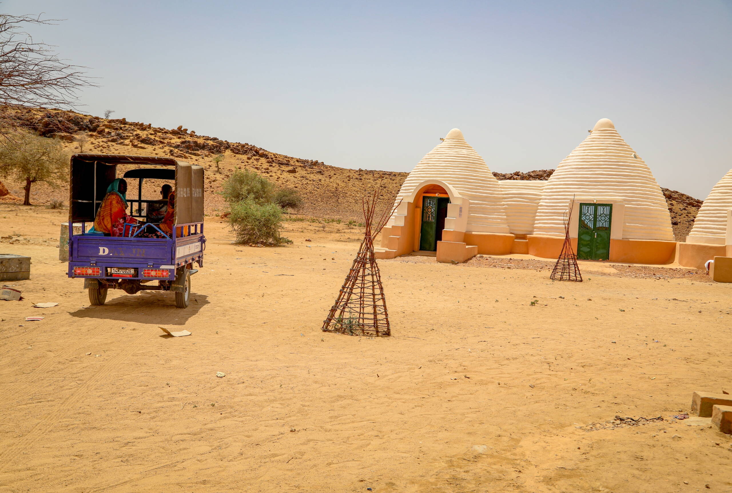 Kuppelartiges Gebäude, links davon ein Motorrad, das mit einer Ladefläche zu einer Ambulanz umfunktioniert wurde.